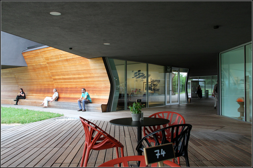 . Huserhaufen - Vitrahaus in Weil am Rhein von Herzog & de Meuron. Im Erdgeschoss wurde ein Teil der Auenwnde schwungvoll gestaltet, mit Holz und integrierter Sitzbank. 20.06.2013 (Matthias)