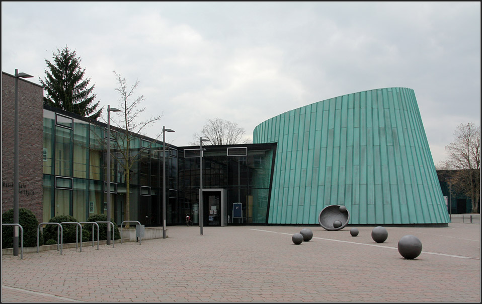 . Musikschule Fellbach: Blick auf den Platz vor dem Eingang mit einem doch recht gelungenen Kunstwerk. Wertung: Sehr schnes der Bauaufgabe angemessenes Gebude, das durch die drei unterschiedliche Bauteile (Klinkerbau, transparenter Bauteil, kupferverkleidert Saal) lebt. Insbesondere beim Saalbauteil passt die Forum zum Inhalt und zur Funktion. Auch stdtebaulich richtig plaziert. 14.03.2011 (Matthias)