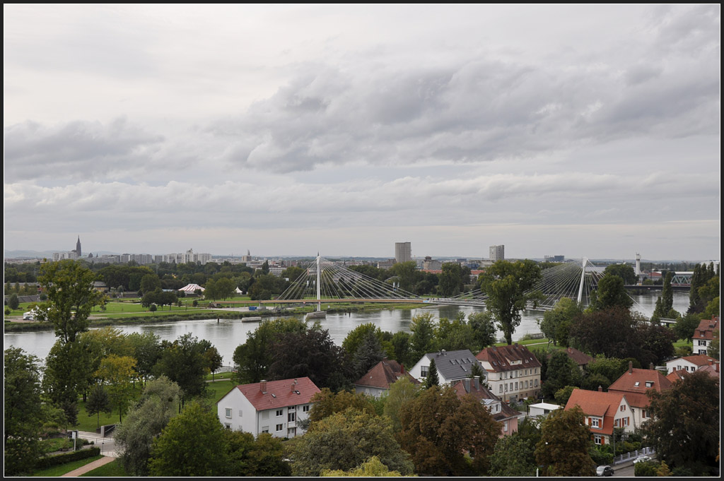 . Straburg von Deutschland aus gesehen - Blick von Kehl ber den Rhein hinber nach Straburg. In Bildmitte ist die Passerelle des deux Rives (Brcke der zwei Ufer) zu sehen, rechts auch die Bahnbrcke zu erkennen. Blick von einem Aussichtsturm, September 2011 (Jonas)