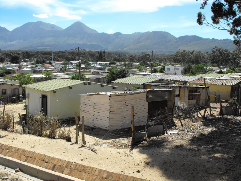 Am Rande der Siedlung entstehen mehr und mehr primitive Behausungen (Shaks).Im HIntergrund die Hottentots Berge. Sir Lovry's Pass Village, 06.12.2010
