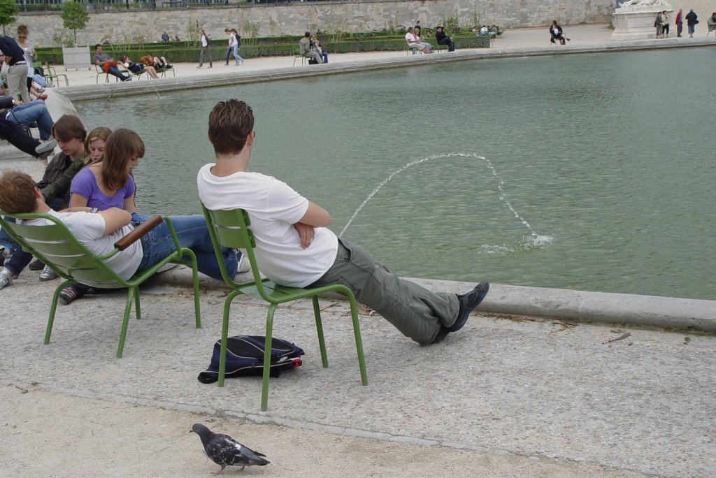 An einem der kleinen runden Wasserbassins im Jardin des Tuileries am 19.07.2009, an dessen Rand sich Touristen und Pariser erholen.