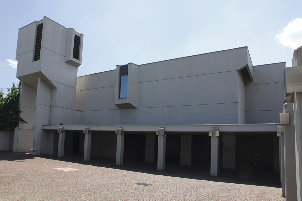 Biel/Bienne, rm.-kath. Kirche Christ-Knig, Betonbau 1967-68 von Walter Moser. Blick vom Innenhof in Richtung Westen mit Kirche und Glockenturm. Die geplanten 4 Glocken wurden nie aufgezogen. Sichtbeton wurde nachtrglich und nur aussen mit etwas Farbe bertncht, sodass die Fassaden nun etwas freundlicher aussehen, 23. Mai 2010, 14:55