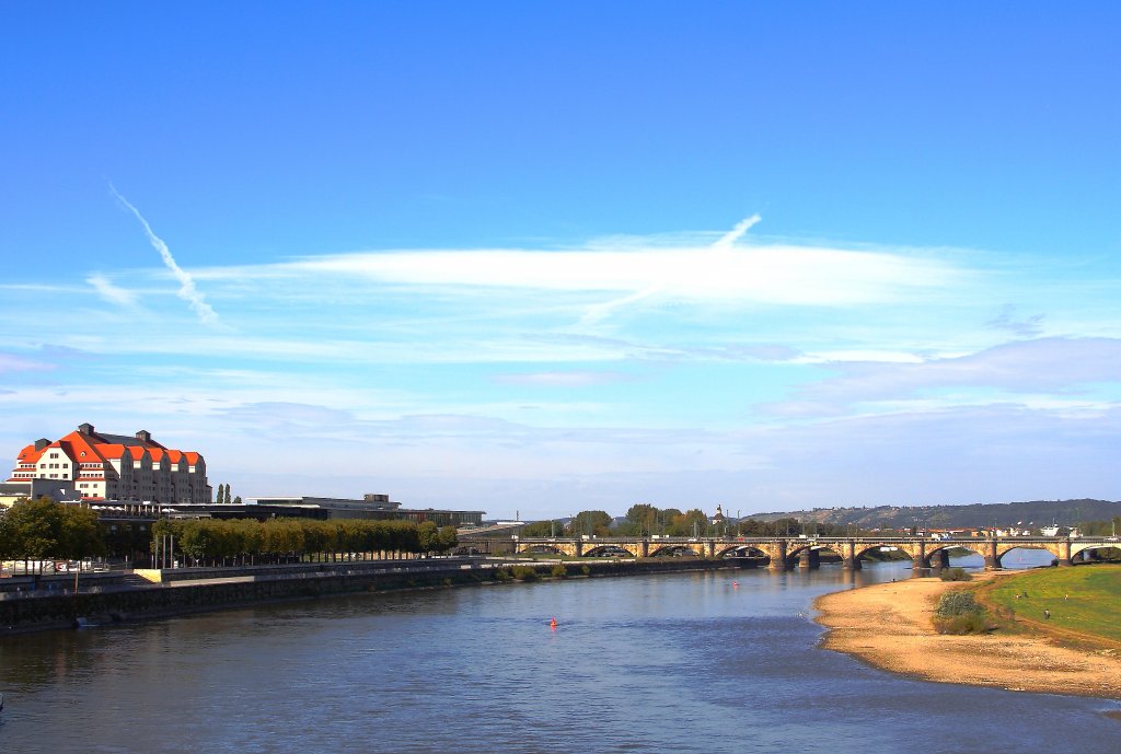 Blick am 06.10.2011 von der Dresdener Augustusbrcke elbabwrts in Richtung Marienbrcke. Das wei-rote Gebude am linken Bildrand ist der ehemalige Erlwein- Speicher, welcher in den Jahren 1913-1914 durch den Dresdner Stadtbaurat Hans Erlwein in Stahlbeton-Skelettbauweise errichtet wurde und damals als Lager fr Tabak, Wolle, Gewrze und Stoffe diente. Als das lteste Bauwerk des Ensembles  Neue Terrasse  wurde es 2004-2006 als Kongress-Hotel umgebaut und gehrt seither zur  Maritim -Gruppe. Im Hintergrund sind die Radebeuler Weinberge zu sehen.