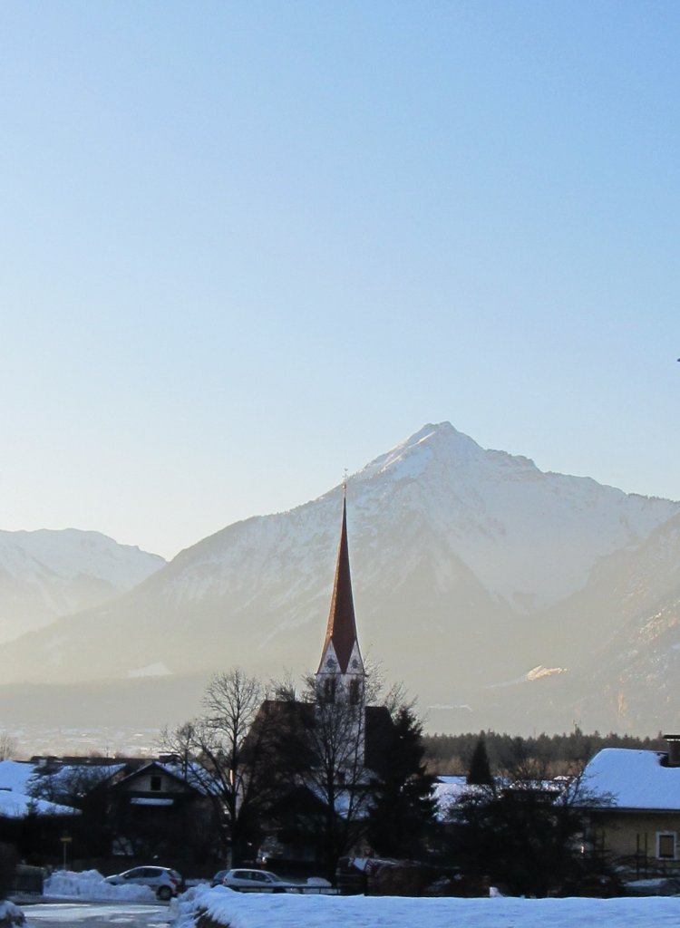 Blick auf den Brixlegger Kirchturm und die dahinterliegenden Berge im Abendlicht.(12.1.2012)