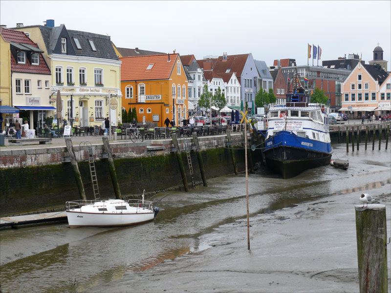 Blick von der Fussgngerbrcke ber den Hafen mit der NORDERTOR als Schiffsrestaurant und Hafencafe zur Hafenstrae bei Niedrigwasser; 23.05.2010
