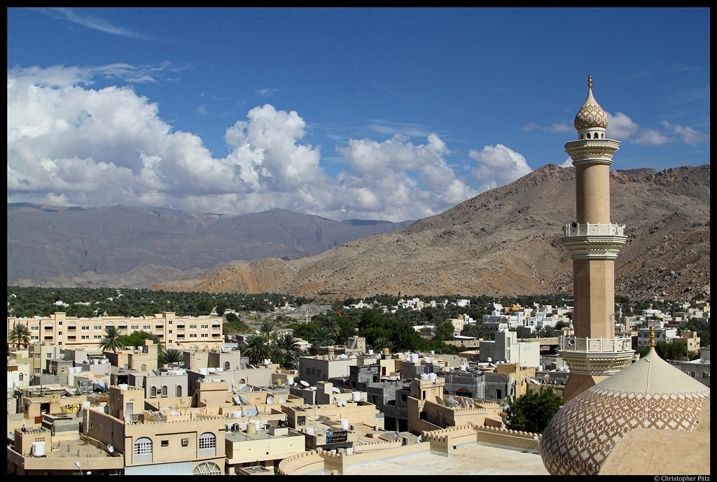 Blick vom Turm der alten Festung auf die Stadt Nizwa. Rechts steht das Minarett der Qabus-Moschee. Im Hintergrund beginnt das Hadschar-Gebirge. (03.12.2012)