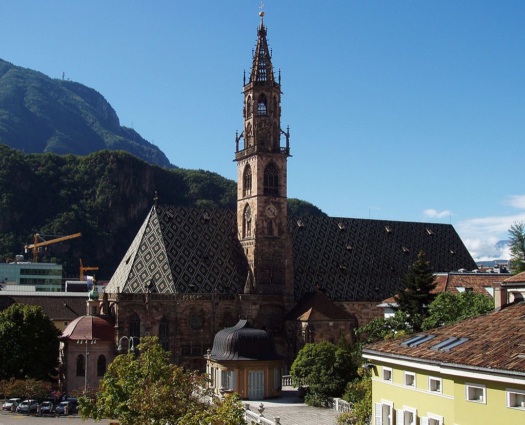 Bolzano/Bozen, Stadtpfarrkirche Maria Himmelfahrt. 1180 gegrndet, 100 Jahre spter Baubeginn, gotisch. Turm mit durchbrochenem Helm, sptgotisch, 1517 beendet. Kirche 1964 zur Konkathedrale erhoben. Aufnahme von Nordosten, 27. Aug. 2006, 10:25