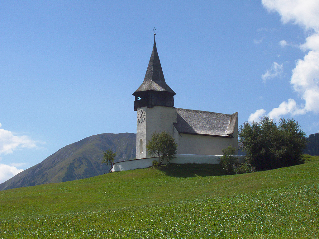 Davos-Frauenkirch, ref. Kirche. Erwhnt 1466, mehrmals erneuert. Polygonaler Turmchor mit Glockenstube und gebrochenem Achteckhelm. Bergseitige Schmalfront des Schiffs als Lawinenbrecher. Aufnahme vom 24. Aug. 2003, 13:05