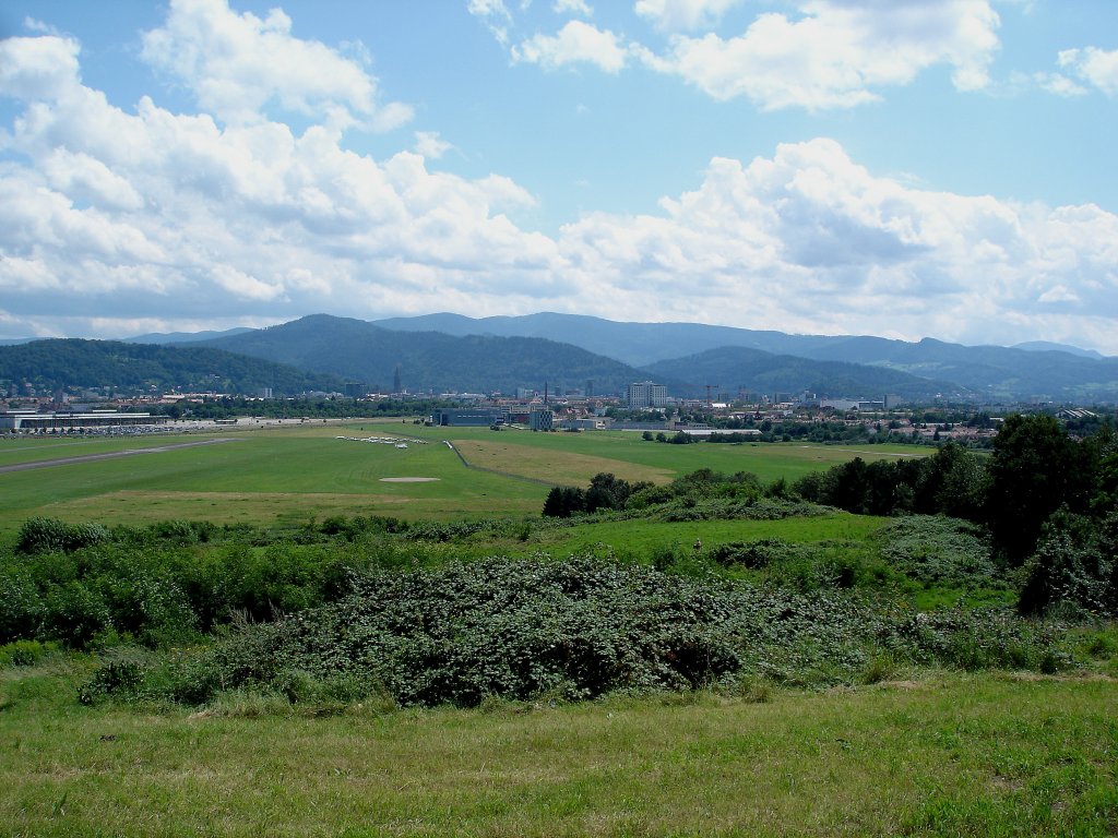 Freiburg, Blick auf den Flugplatz und Messehallen(links) und die Stadt mit den Schwarzwaldbergen, 2009