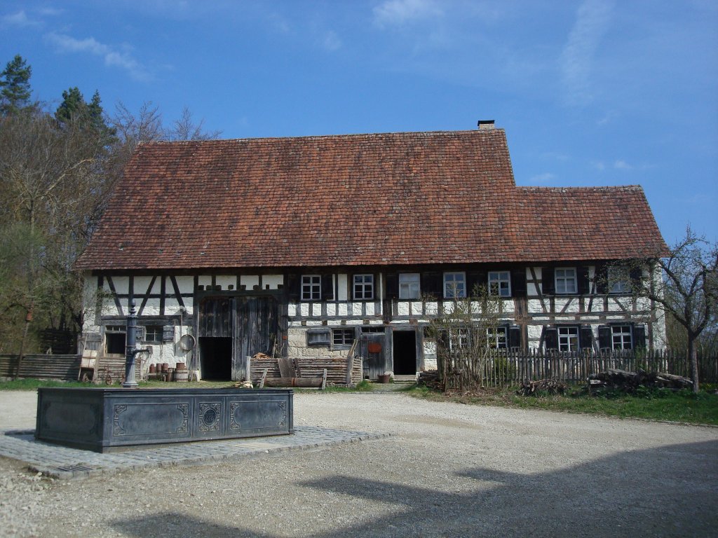 Freilichtmuseum Neuhausen ob Eck,
im 18.Jahrhundert erbautes Bauerhaus aus dem Ort,
davor ein gueiserner Brunnen,
April 2010