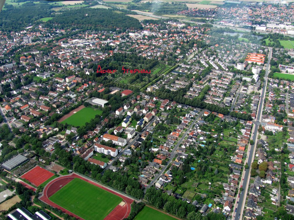 Im August 2010 berfliegen wir die Stadt Peine, rechts verluft die Schferstrae, in der Mitte der Silberkamp, hinten links ist der Herzberg mit dem hellen Punkt des Wasserturmes, dahinter verluft das graue Band der Autobahn A2.