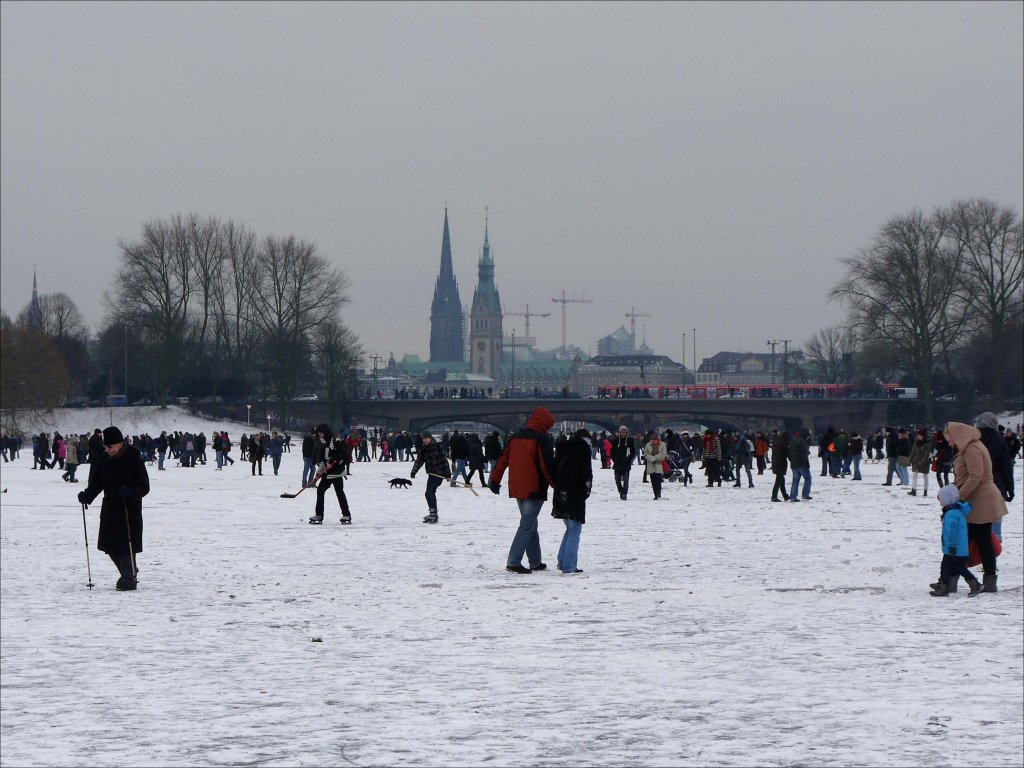 Jung und Alt, mit und ohne Wintersportgeräten, nutzen die Gelegenheit, zu Fuße über die zugefrorene Außenalster zu spazieren; Hamburg, 12.02.2012