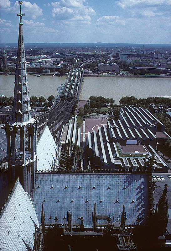 Kln, Hohe Domkirche, Aussichtsplattform auf dem Sdturm. Blick Richtung Osten mit Mittelschiff, neugotischem Dachreiter, Chor, sdlichem Querschiff. Im Hintergrund Rhein mit berdurchschnittlich hohem Pegel wegen entsprechenden Niederschlgen, Hohenzollernbrcke, Kln-Deutz. Aufnahme von Aug. 2002, HQ-Scan ab Dia.