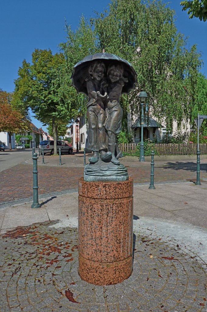 Neuenburg am Rhein,  Kinder unterm Regenschirm , ein Brunnen vom Knstler Frido Graziani, aufgestellt 1989, Aug.2011