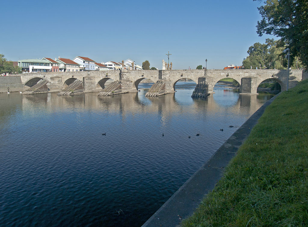 Pisek, etwa 100 km sdlich von Prag gelegen, ist eine typisch bhmische Stadt. Die Steinbrcke ber die Otava, etwa 110 Meter lang und 6,6 Meter breit, ist heute ausschlielich Fugngern vorbehalten. Bekannte Bilder vom Hochwasser 2002 zeigten die Macht des Wassers, von der Brcke einschl. Gelnder war nichts mehr zu sehen, nur der heilige Nepomuk in der Mitte war noch ber dem Wasser. Am 01.10.2011 konnte man sich das alles nicht mehr richtig vorstellen, dazu trgt auch die mustergltige Restaurierung des Bauwerkes bei. 