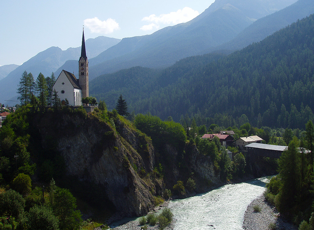 Scuol, ref. Kirche St. Georg, direkt am Felsabhang zum Inn. Unterbau Turm romanisch, einschiffiges Langhaus mit Chor ab 1516, sptgotisch. Erhhung Turm mit Wimpergen und Spitzhelm 1564. Aufnahme Richtung Osten vom 08. Aug. 2003, 10:44