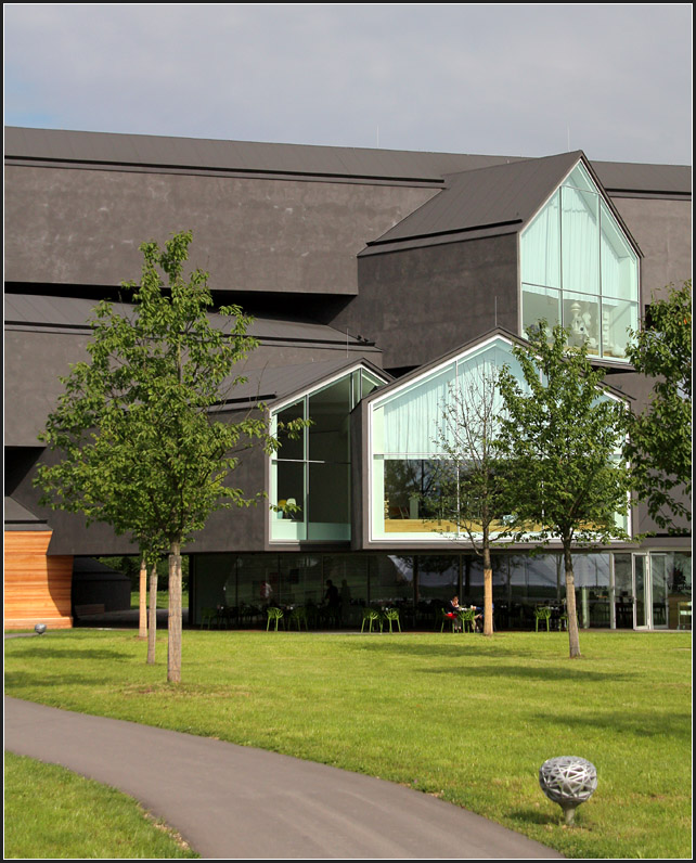 Vitra-Haus in Weil am Rhein, ein Ausstellungsgebude der Designfirma Vitra. Das Bauwerk besteht aus zahlreichen langgezogen aufeinander gestapelten Satteldachhuser. Geplant wurde es von den bekannten Basler Architekten Herzog & de Meuron, fertig wurde es im Jahre 2010. 29.08.2010 (Matthias)