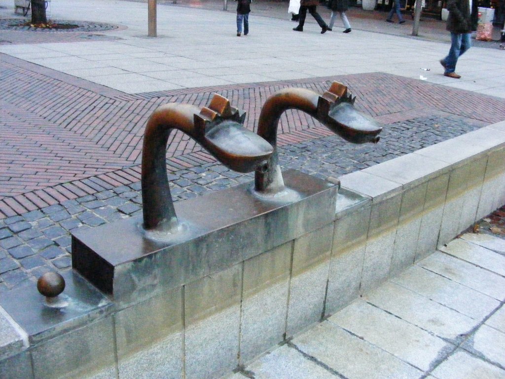 Zwei Wasserspeier an einem modernen Brunnen auf der Knigstrae in Duisburg am 6. November 2009. 
