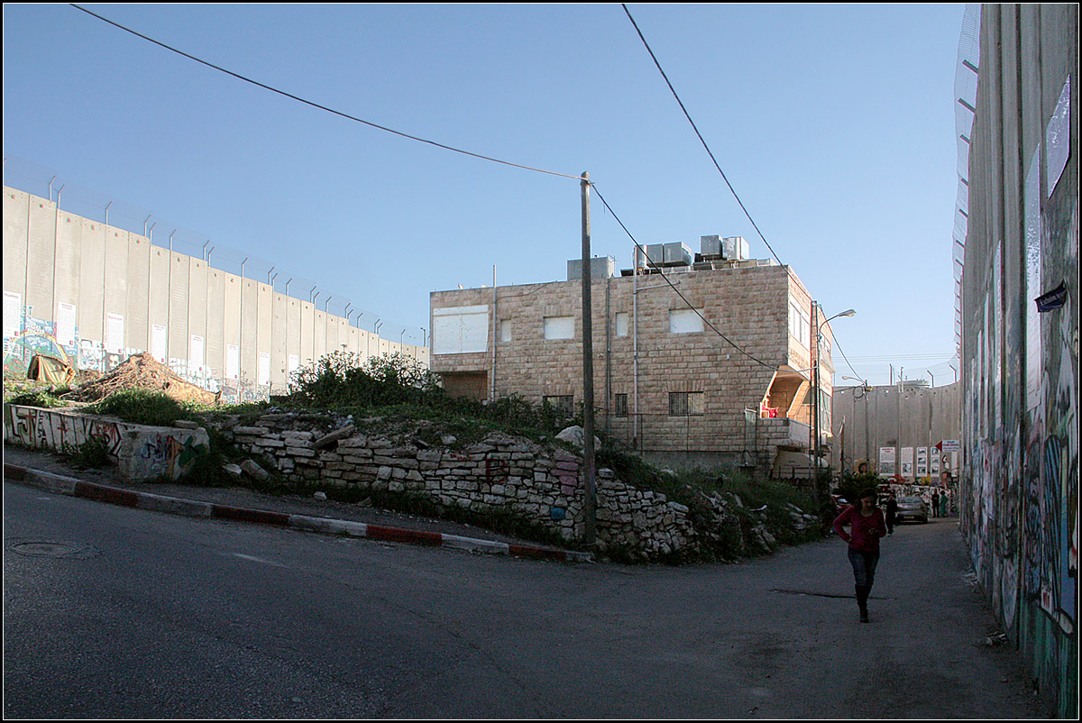 . Bethlehem, jenseits von Weihnachten -

Dieses palstinensische Haus ist auf drei Seiten von Mauern umgeben. Frher war die Strae auf der linke Seite die Hauptstrae die von Jerusalem kommend nach Bethlehem hinein fhrte. Auf der anderen Seite befindet sich Rahels Tomb (das Grab von Rahel der Frau von Jakob). Da es um diese wichtige heilige Sttte fr das Judentum immer wieder Auseinandersetzungen mit den Palstinensern gab, wurde es schlielich durch den Bau dieser Mauer, die ganz verschlungen nach Bethlehem hineinreicht und das Rahels Tomb umschliet, vom Westjordanland abgegrenzt. Die Frau auf dem Bild wohnt in diesem Haus und hat uns dann ber die absurde Situation erzhlt.-

Im Stadtplan ist der Separation Wall als dnne schwarze Linie dargestellt.

27.03.2014 (Matthias)