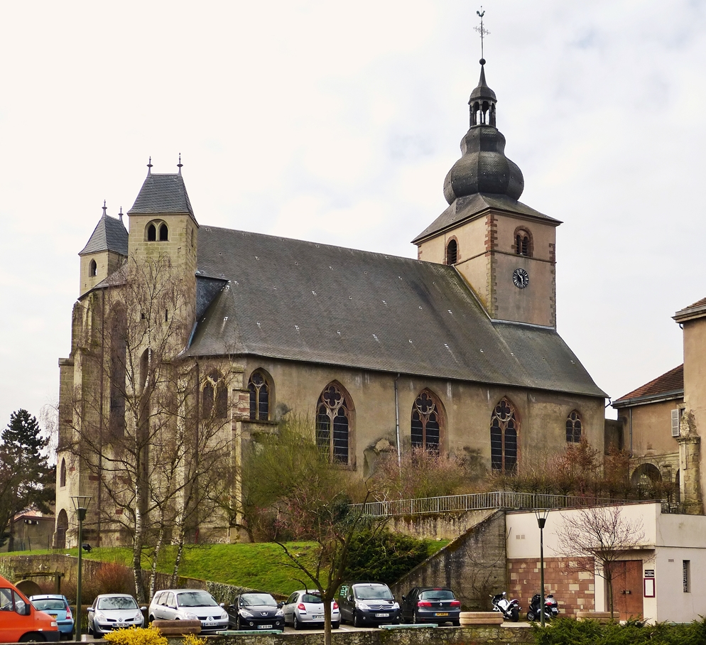 . Bouzonville - Die ehemalige Klosterkirche Heilig Kreuz (Sainte Croix) in Bouzonville (deutsch Busendorf, lothringisch Busendroff) im Dpartement Moselle in der Region Lothringen. 03.04.2015 (Hans)

Die Kirche ist eine querhauslose gotische Pseudo-Basilika mit offener Vorhalle. Der Turm erhielt in der Barockzeit eine welsche Haube. Das Chorgesthl mit figrlichen Schnitzereien entstammt der Barockzeit. Der Chorabschluss der Kirche verfgt ber zwei fr Lothringen typische Chorflankentrme. Das Mittelschiff ist 17 m hoch, die Seitenschiffe erreichen eine Hhe von 10 m.
