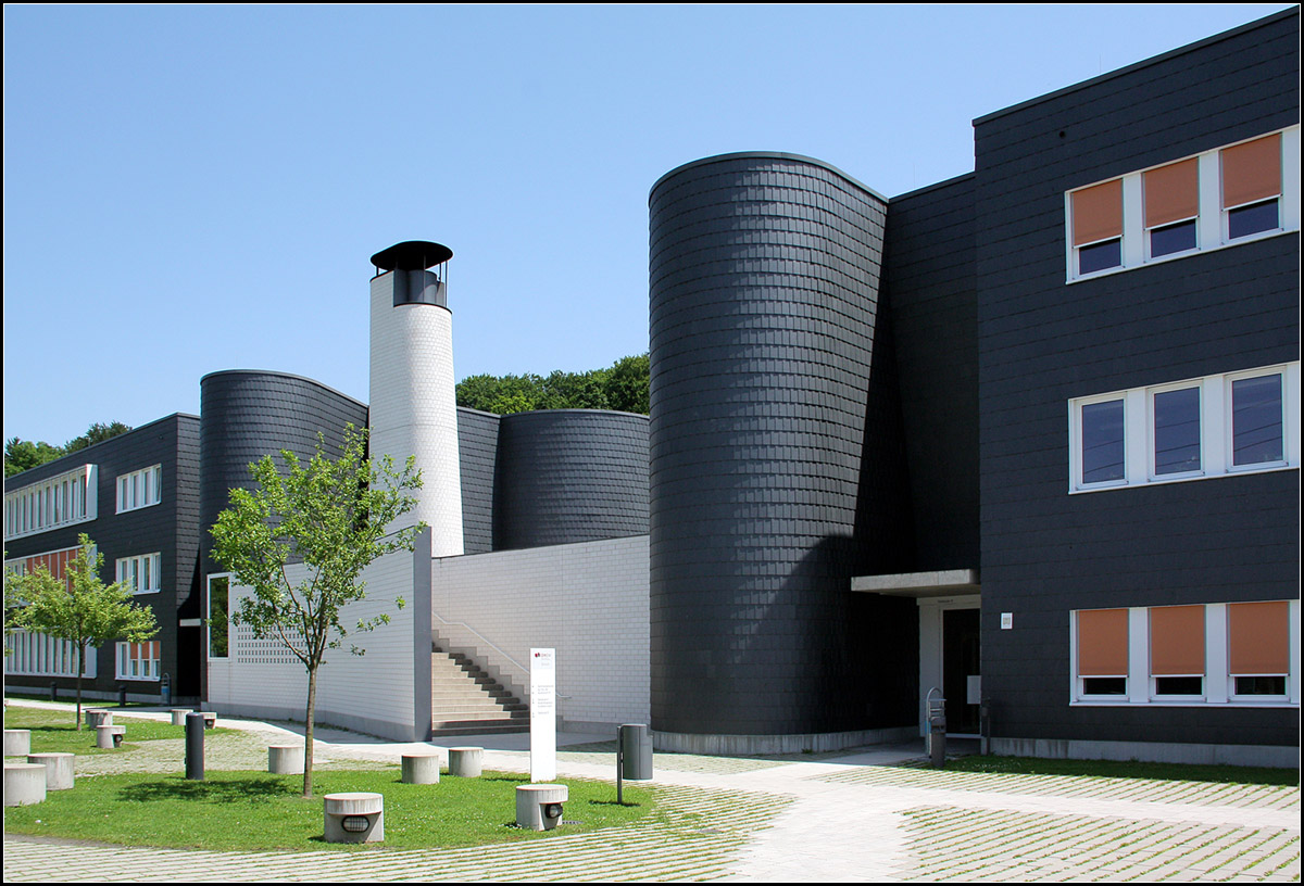 . Duale Hochschule Lrrach -

Blick vom Hof auf den oberen Bauteil der Schule. Runde Treppentrme und der Kamin brechen die rechtwinklingen Bauteile auf. Die Treppe fhrt zu einem Durchgang zu den Parkpltzen entlang der Strae. LRO-Architekten.

18.06.2013 (Matthias)