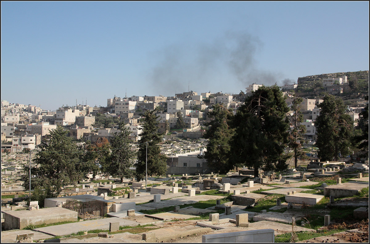 . Rauch ber Hebron -

Solche schwarze Rauchwolken sieht man in palstinensischen Stdte und in Ostjerusalem immer wieder. In den Straen sind Mllcontainer aufgestellt, in denen der Hausmll entsorgt wird. Dies Container werden immer mal wieder angezndet. Mllverbrennung der anderen Art.

Wir stehen hier in der Nhe der Abrahams Quelle und blicken ber den Muslimischen Friedhof auf Herbron.

22.03.2014 (Matthias)