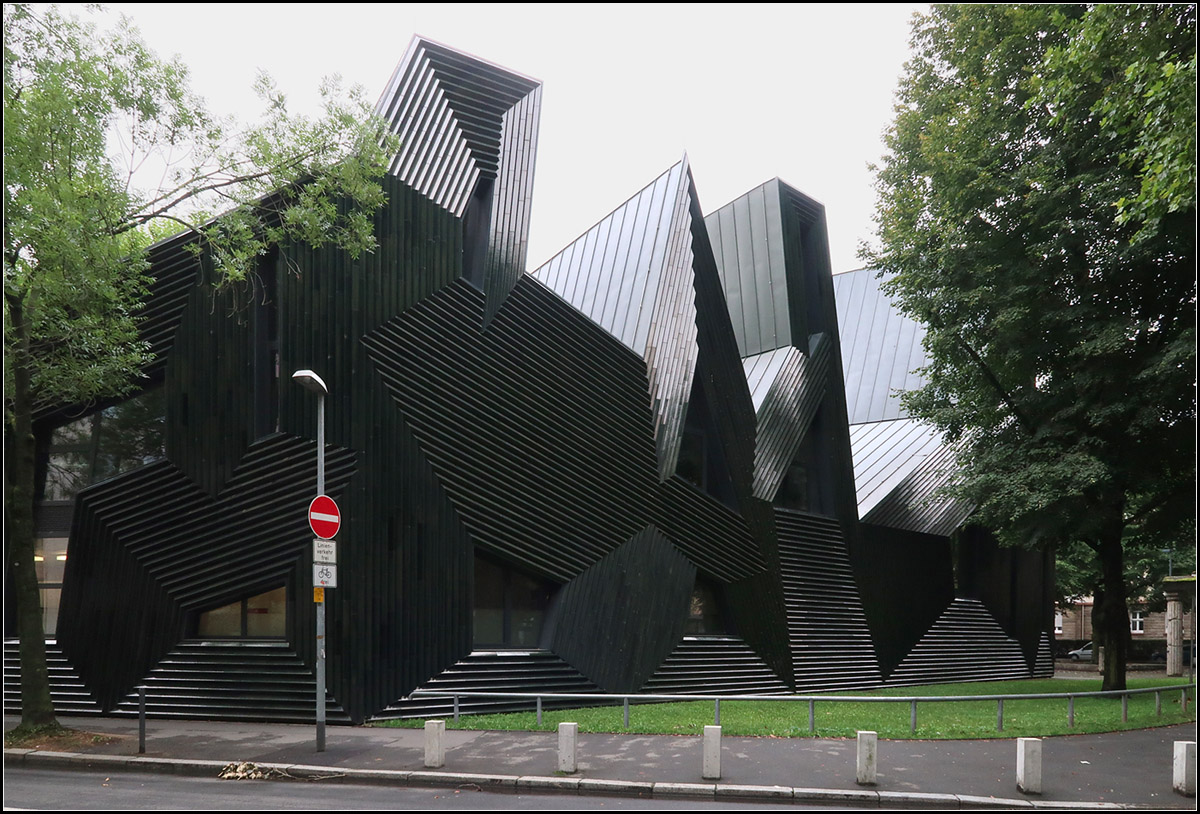 . Ungwhnlich -

... in Form, Farbe und Material, die neue Synagoge in Mainz. Geplant von Manuel Herz, eingeweiht im Jahr 2010.  Hier ein Link zu einer Meldung im Baunetz, wer den Bau besser verstehen will:

https://www.baunetz.de/meldungen/Meldungen-Synagoge_von_Manuel_Herz_in_Mainz_eingeweiht_1297777.html

Leider war bei unserem Besuch recht tristes, nasses Wetter, aber trotzdem oder vielleicht gerade aufgrund der Nsse kommen die Lichtreflexionen auf der Metal- und Keramikfassade schn zur Geltung.

12.08.2017 (M)