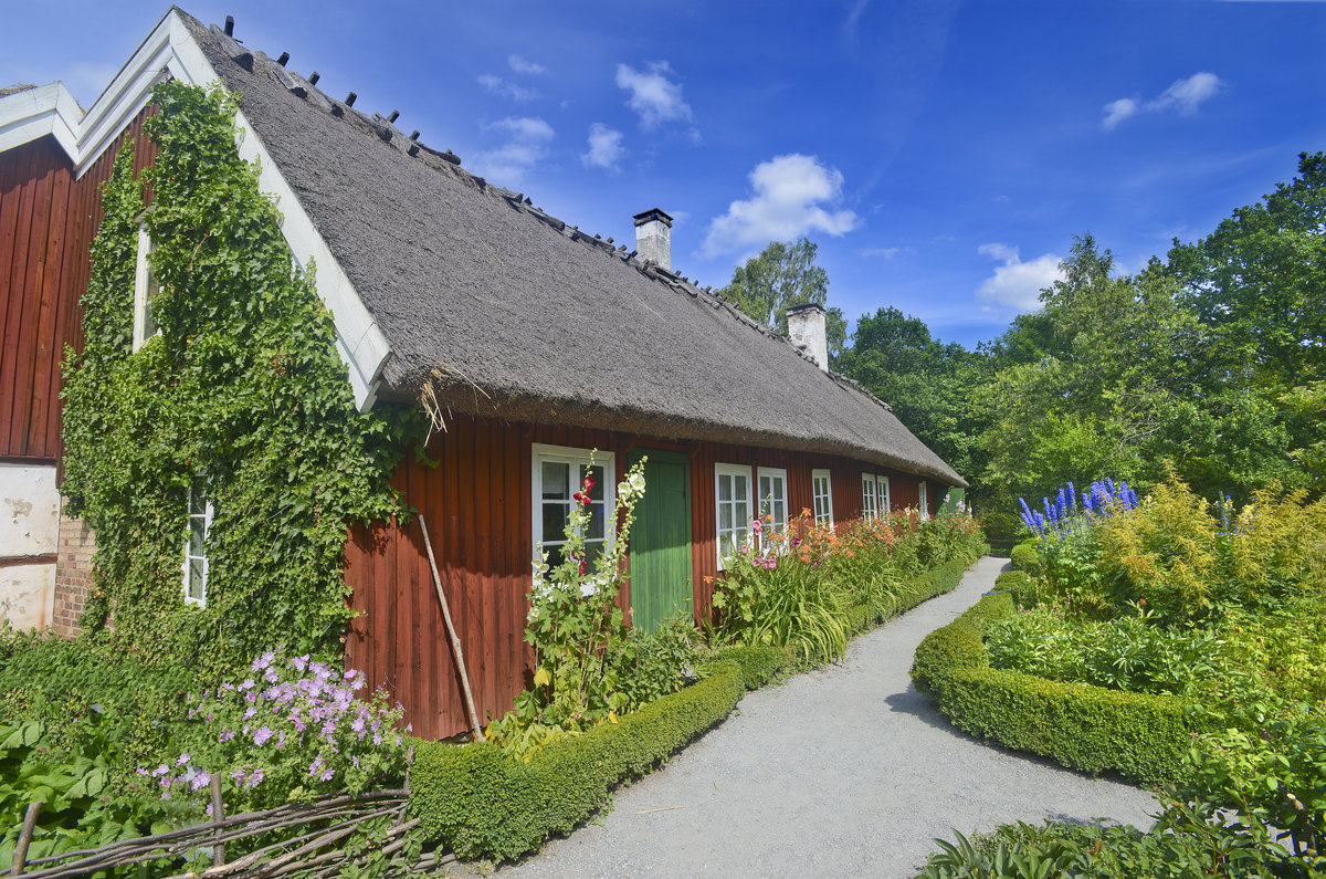 Sknegrden im Stockholmer Freilichtmuseum Skansen. Ungefhr 150 Gebude aus allen Landesteilen und aus unterschiedlichen sozialen Umgebungen wurden in das Museum berfhrt: von Bauernhfen aus unterschiedlichen Regionen ber ein Handwerksviertel und Brgerhuser.
Aufnahme: 26. Juli 2017.