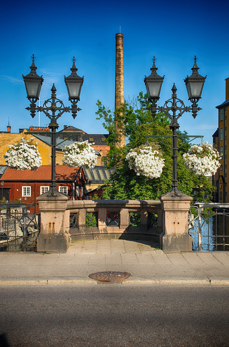 Alte Straenbeleuchtung auf der Brcke Bergsbron in Norrkping. Entlang des Motala strm liegt die so genannte Industrielandschaft, die hauptschlich aus alten Fabrikgebuden aus der Zeit zwischen 1850 und 1917 besteht
Aufnahme: 22. Juli 2017.