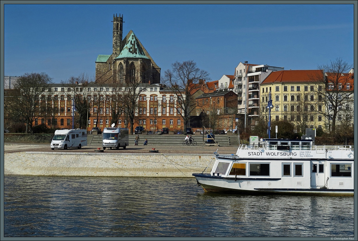 Am Petrifrder liegt der Anlieger der Magdeburger Weien Flotte, deren Fahrgastschiffe (u.a. die  Wolfsburg ) zu verschiedenen Rundfahrten auf der Elbe unterwegs sind. Im Hintergrund ist die aus dem 13. Jahrhundert stammende Wallonerkirche zu sehen. Dieser Teil Magdeburgs gehrte zum sogenannten  Knattergebirge , einst eine der am dichtesten bebauten Wohngebiete Europas, das im 2. Weltkrieg allerdings weitgehend zerstrt wurde. (Magdeburg, 30.03.2018)