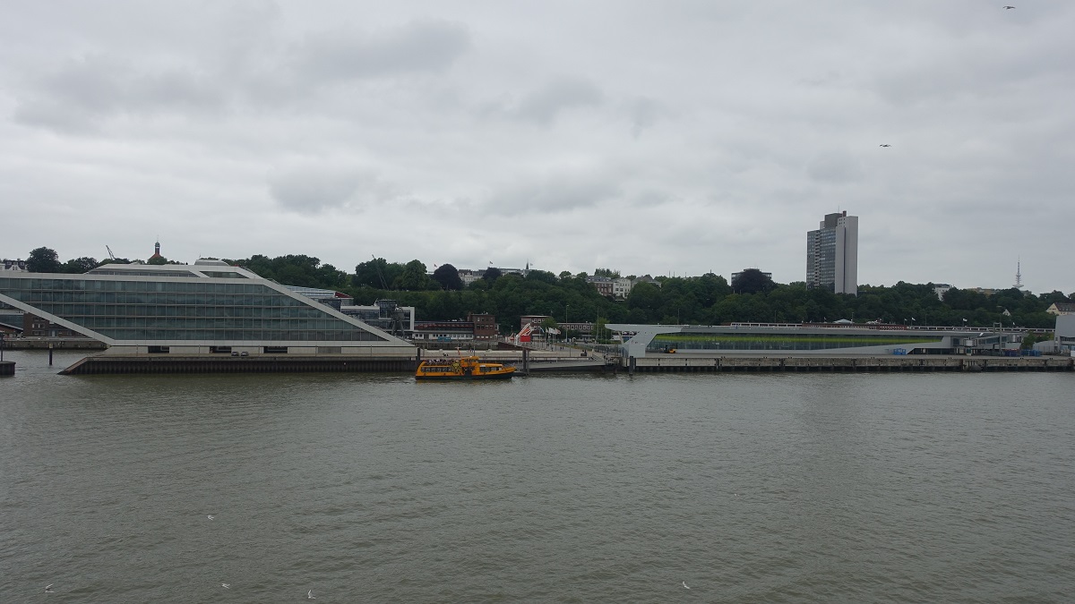 an der Elbe am 14.7.2019: Hamburg, Dockland, links das Gebude der Nordakademie Graduate School (Entwurf Hadi Teherani), mittig der Anleger der HADAG-Fhren, rechts das Cruises Center Altona, Foto von Bord der CAP SAN DIEGO /  