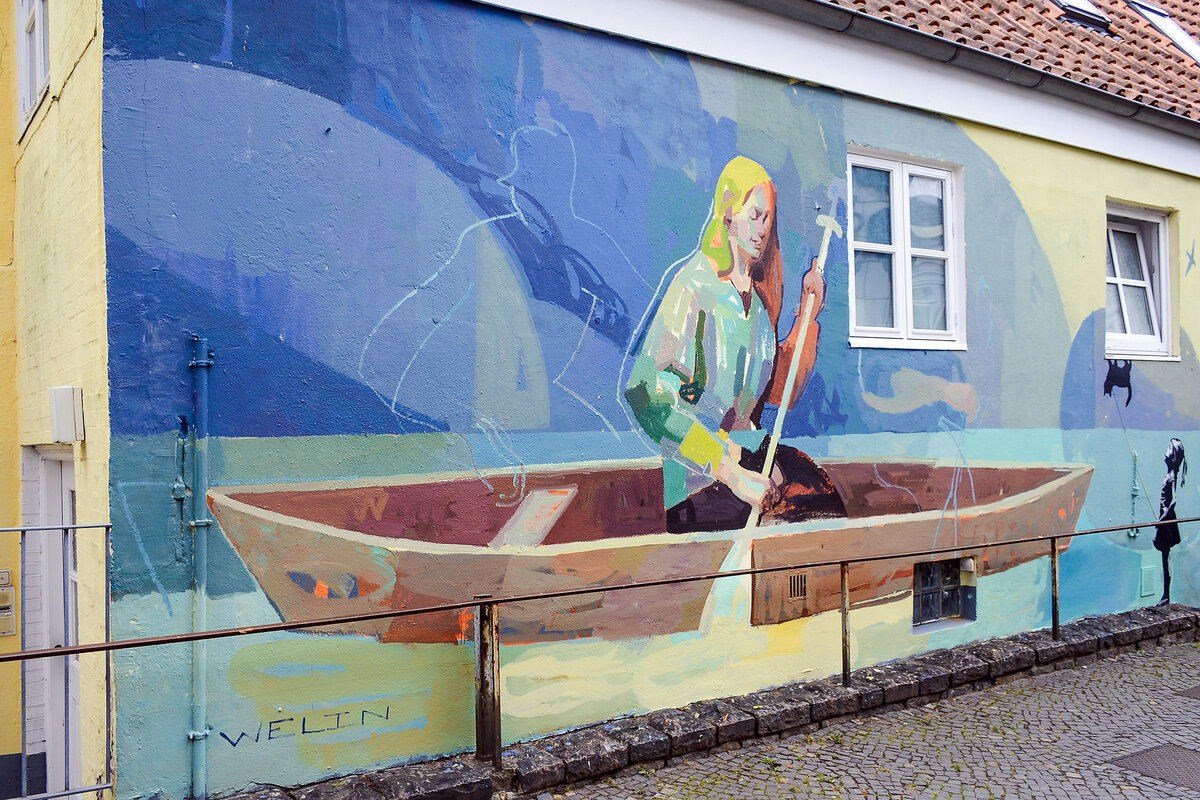Andreas Welins Wandmalereien greifen das t�gliche Leben der Menschen vor. Diese Wandmalerei befindet sich an der Marientreppe in Flensburg und ist ein tel der Nord:Syd Freiraumgalerie. Aufnahme: 26. Juli 2026.