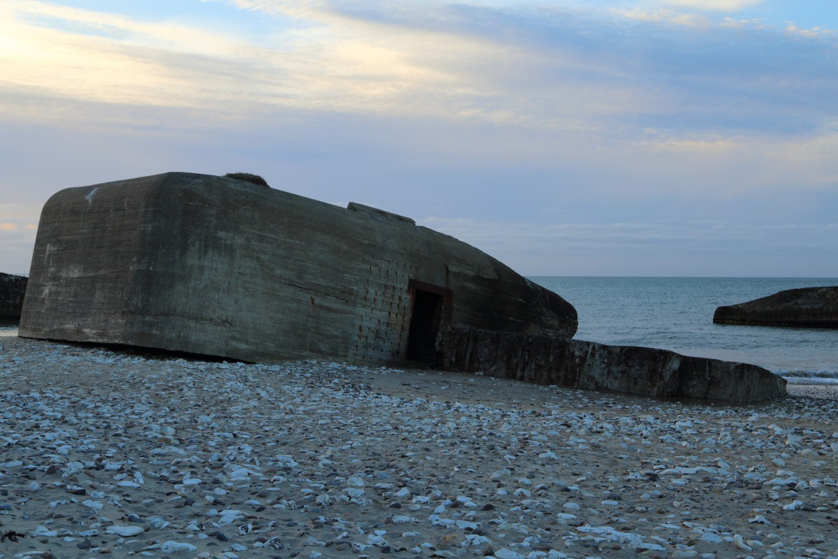 Atlantikwallbunker des II.Weltkrieges am Strand von Vigs, aufgenommen am Abend des 16.04.2014. Wie man auf diesem Bild sehr schn sehen kann, hat die Natur im Laufe der Jahre das geschafft, was mit Granaten und Sprengstoff nicht zu erreichen war. Durch die stndige Arbeit des Wassers sind die Bunker mittlerweile alle untersplt und neigen sich dem Meer entgegen. Auch am Beton ist der nagende Zahn des Meerwassers deutlich zu erkennen. Irgendwann werden diese Schandflecke, produziert von damaligem deutschen Grenwahn, vollstndig verschwunden sein. Das ist nur eine Frage der Zeit. So holt sich auch hier die Natur langsam all das zurck, was ihr rechtmig gehrt und ihr der Mensch in frevelhaftem Vorhaben einst genommen hatte. Und ich denke, das ist auch gut so!