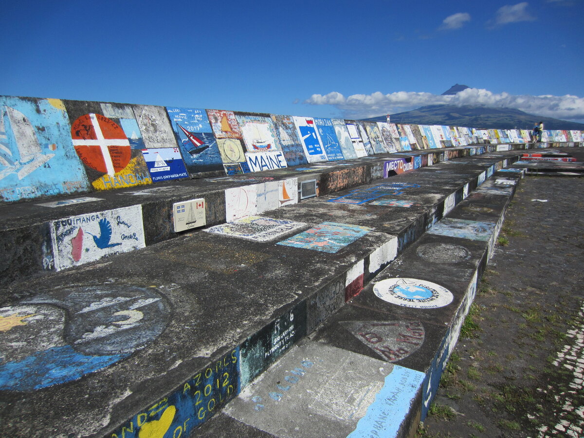Auf dieser Kaimauer im Hafen von Horta verewigen sich Skipper, die auf den Azoren einen Zwischenhalt einlegen, mit kleinen Kunstwerken. Gesehen am 26.07.2023.