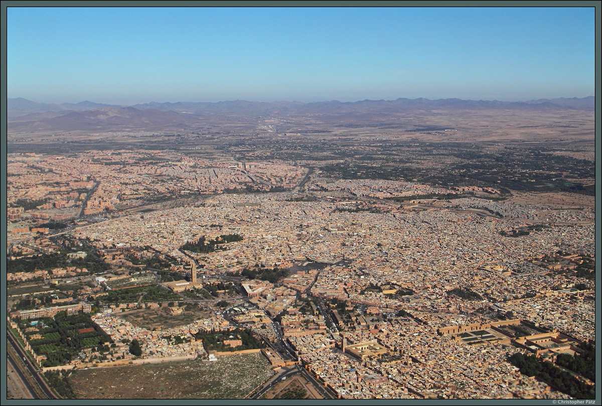 Aus dem startenden Flugzeug bietet sich am 25.11.2015 noch einmal ein letzter, beeindruckender Blick auf die Stadt Marrakesch: In der Mitte ist die dicht bebaute Medina zu sehen, welche von einer Stadtmauer umgeben ist. Im Zentrum befinden sich der Djama el-Fna sowie die Kutubiya-Moschee (links davon). Am unteren Bildrand ist in der Mitte die Kasbah-Moschee zu erkennen, wo sich auch die Saadiergrber befinden. Rechts davon ist der El-Badi-Palast zu sehen. Links, auerhalb der Medina, schliet sich die Neustadt an.