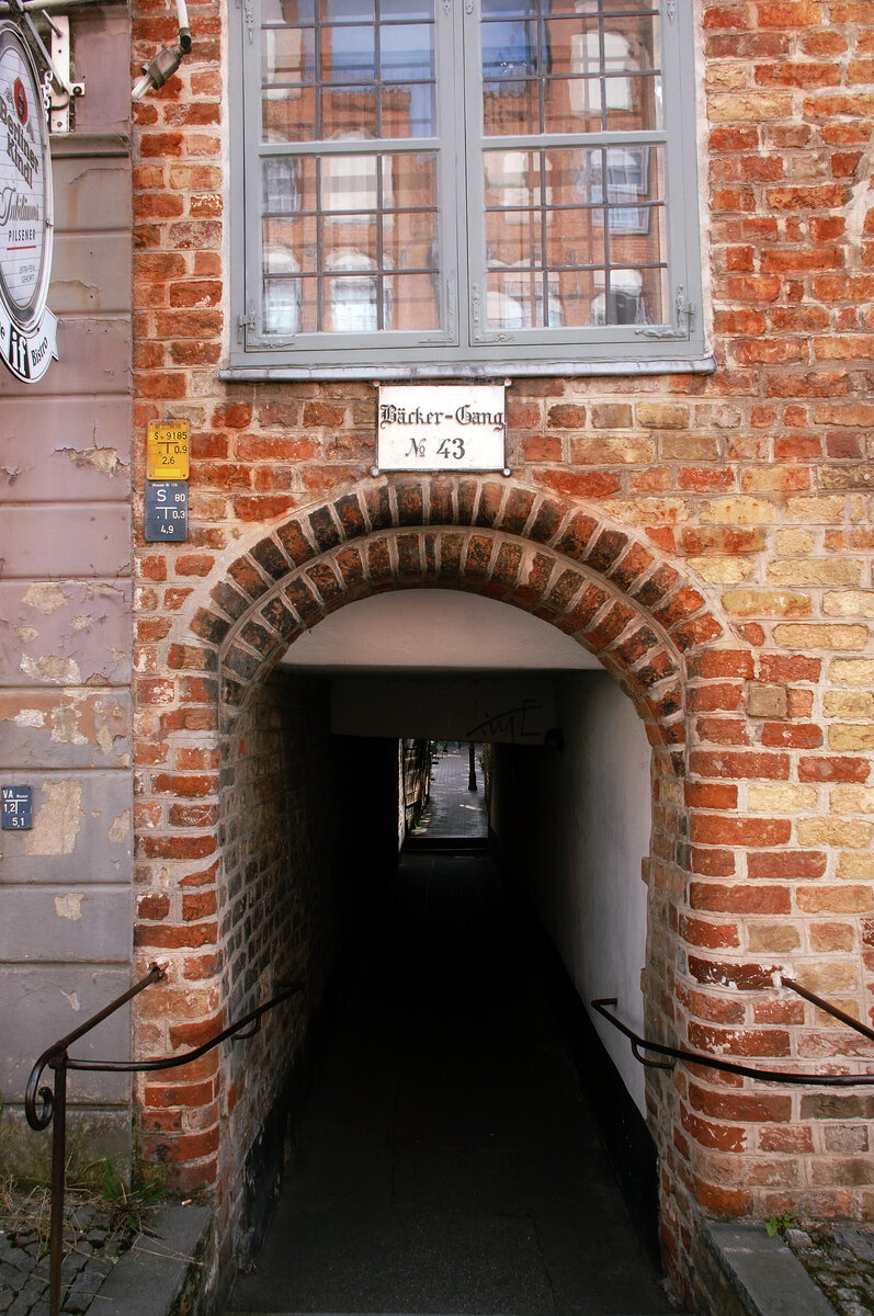 Bckergang in der Lbecker Engelsgrube. Der Gang bildet eine Verbindung zu Lngreens Gang. Einer von Lbeckschen Fremdenfhrern gerne erzhlten Legende nach musste lediglich die Grundvoraussetzung erfllt sein, dass ein Sarg hindurchgetragen werden konnte. Die Gnge in der Lbecker Innenstadt sind lediglich schmale Durchgnge, die heutzutage nur noch gelegentlich die andere Straenseite des Quartiers erreichen. Aufnahme: 21. September 2021.