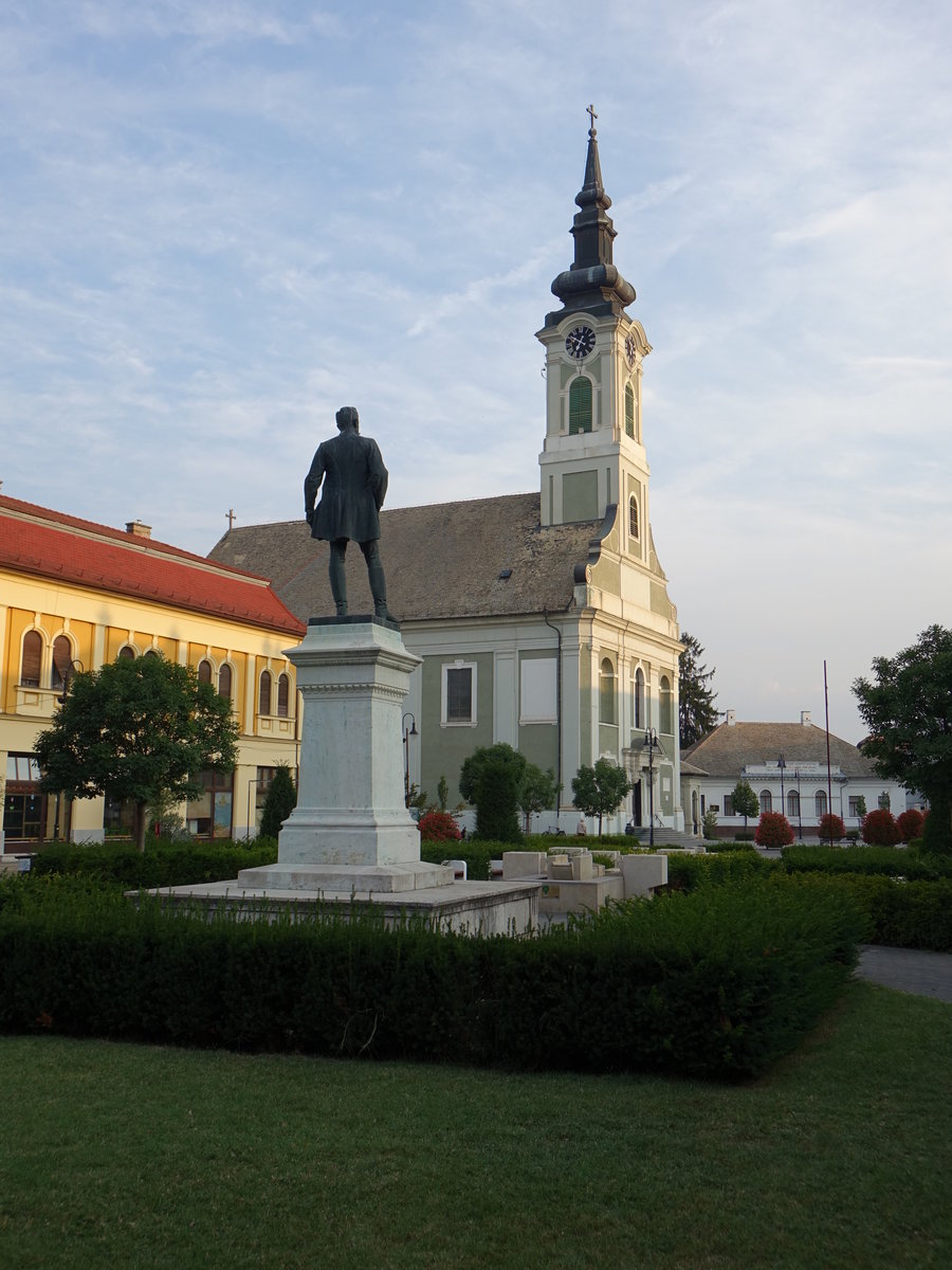 Baja, St. Peter und Paul Kirche am Toth Kalman Ter, erbaut bis 1765, davor das Denkmal fr den Dichter Kalman Toth (24.08.2019)