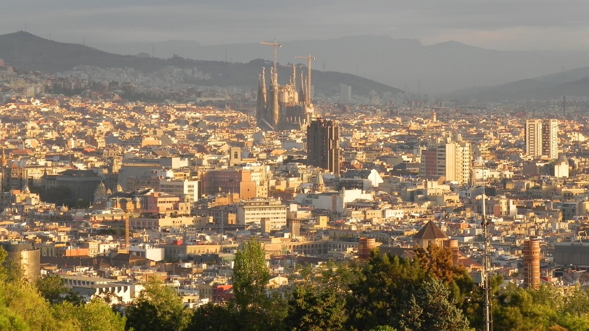 Barcelona mit der Basilika  Sagrada Familia  in der Mitte am Morgen des 11.10.2016. Mit dem Bau der bis heute unvollendeten Kirche nach dem Entwurf des spanischen Architekten Antoni Gaud wurde im Jahr 1882 begonnen und sollte bis zu seinem 110. Todestag 2026 fertiggestellt sein. Aufgrund der Covid-19-Pandemie kann dieses Datum nicht eingehalten werden.