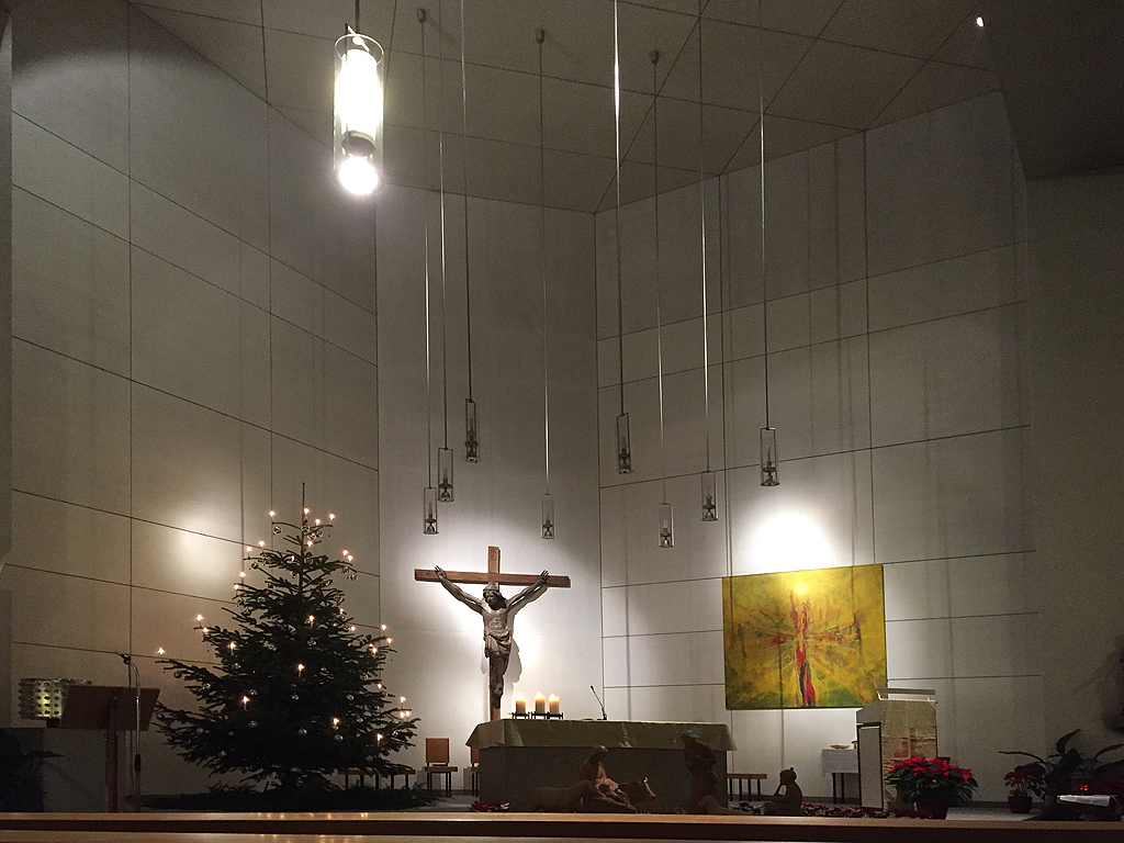 Biel/Bienne, rm.-kath. Kirche Bruder Klaus, Innenaufnahme mit Blick zum Chor mit Kruzifix (15. Jhr.). Der karge Betonbau von Hermann Baur wurde 1957-58 gebaut und ist neben St. Marien und Christ-Knig die 3. rm.-kath. Kirche in Biel. Aufnahme bei Mitternachtsmesse vom 24. Dez. 2016, 23:56