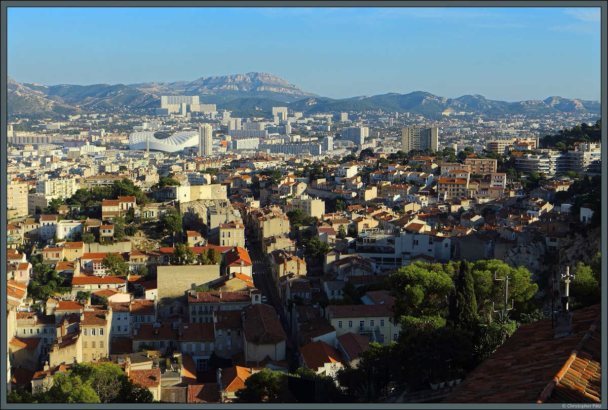 Bis zum Horizont ziehen sich die Huser von Marseille. Vorn ist die kleine Kirche Saint-Franois d'Assise zu sehen, im Hintergrund dominiert das Fuballstation Stade Vlodrome. (Blick von der Wallfahrtskirche Notre-Dame de la Garde, 29.09.2018)