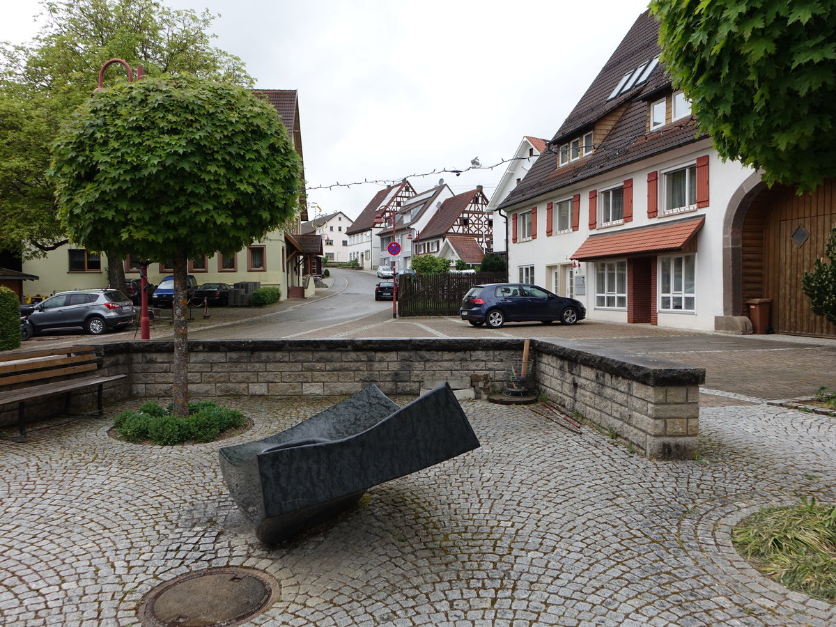Bittelbronn, Brunnen am Kirchplatz, dahinter Gebude in der Dettinger Strae (10.05.2018)