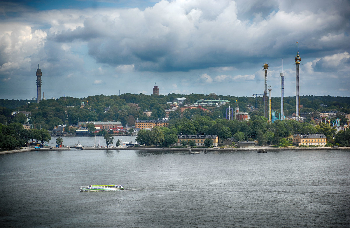 Blick auf die Insel und den Stadtteil Djurgrden vom Gondolen in Stockholm. Am zentralen Djurgrdsvgen liegen eine Reihe von Museen, wie zum Beispiel das Vasa-Museum, das Nordische Museum, das Abba-Museum, Liljevalchs Kunsthalle, Aquaria Vattenmuseum, das Spritmuseum und das Kinderliteratur-Museum Junibacken, die Estonia-Gedenksttte, Vergngungssttten, wie zum Beispiel Grna Lund und der Circus
Aufnahme: 25. Juli 2017.