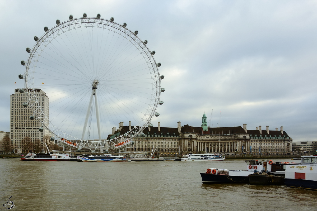 Blick auf das Sdufer der Themse auf das London Eye oder Millennium Wheel genannte Riesenrad und die County Hall in London. (Februar 2015)