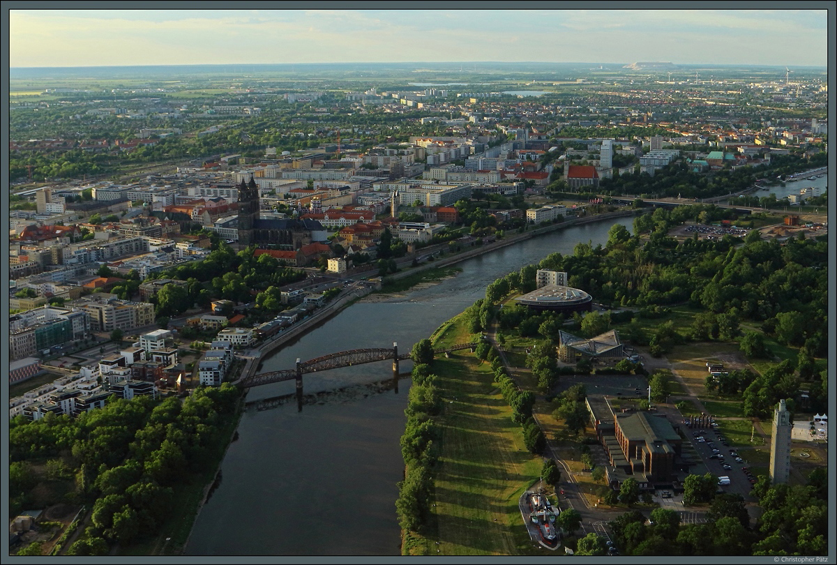 Blick aus dem Ballon auf das Stadtzentrum von Magdeburg: Links der Elbe liegt der Stadtteil Altstadt mit dem Magdeburger Dom. Rechts der Elbe der Stadtpark Rotehorn, vorn mit Stadthalle und Albinmllerturm, dahinter die Hyparschale und das MDR-Funkhaus. (29.05.2020)