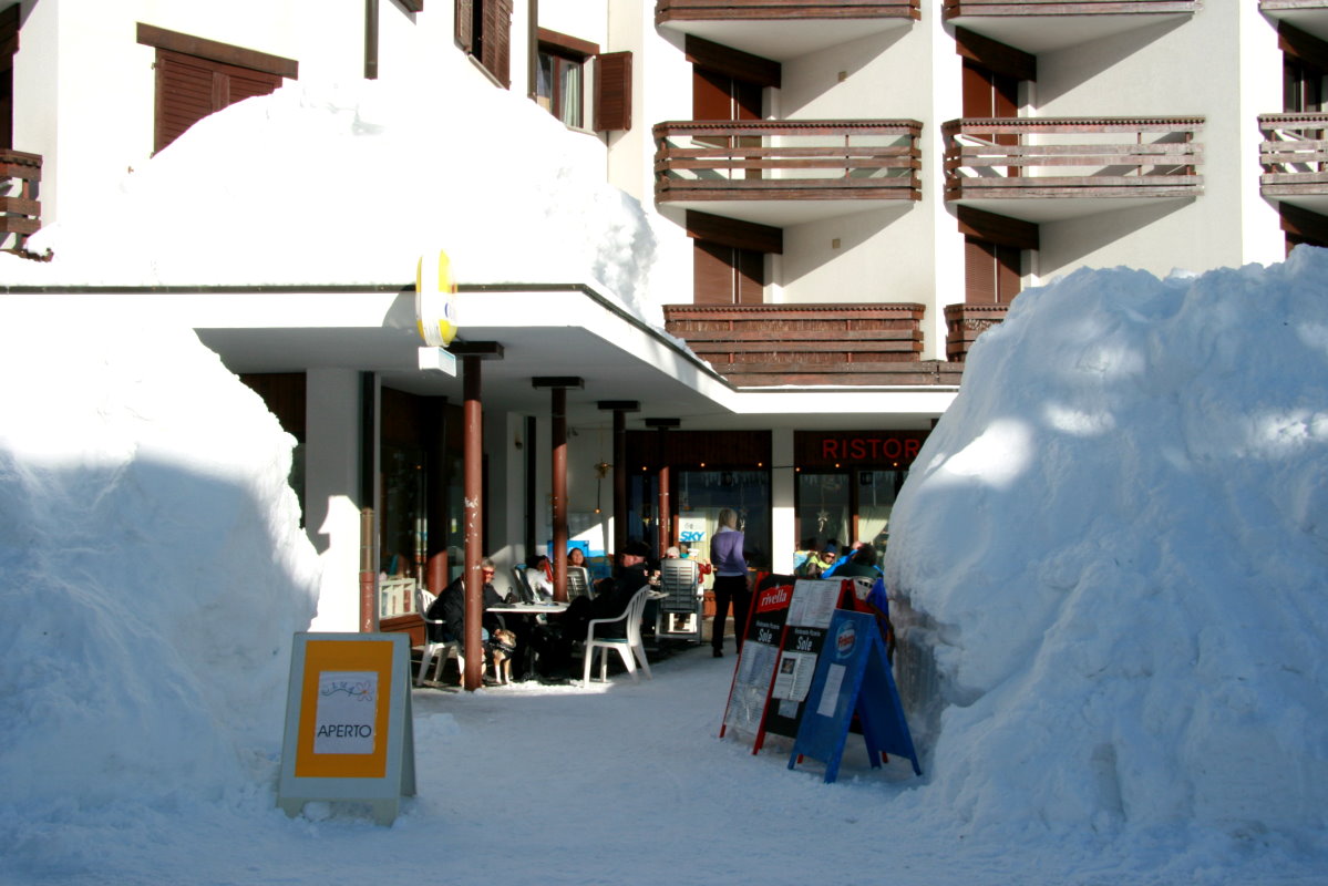 Blick durch die Schneeberge zu einer gut besetzten Caf-Terrasse in San Bernardino; 09.02.2014