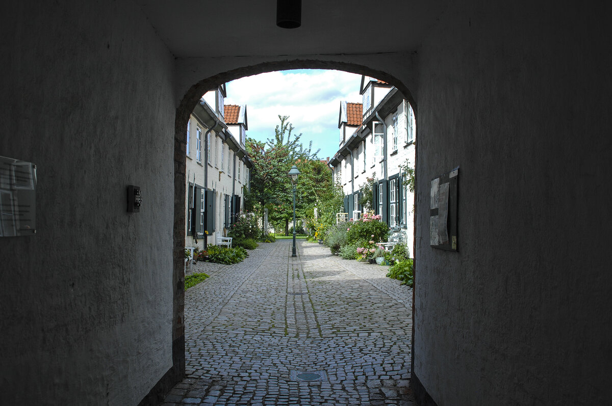 Blick in Glandorps Hof in der Lbecker Innenstadt. 1612 gestiftet von Johann Glandorp. ltester der greren Stiftungshfe der Stadt. Vorderhaus aus der Grndungszeit als langes Traufenhaus mit getreppten Zwerchgiebeln ausgebildet. Stiftungsinschrift und -wappen ber dem Durchgang. Traufenhausflgel im Hof mit Wappen von 1609, 1872–84 teilweise erneuert. Mitte der 1970er zu Wohnzwecken durchgebaut. Aufnahme: 21. August 2021.