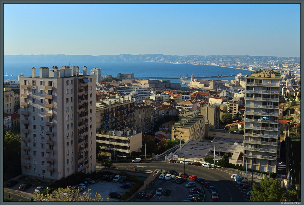 Blick von der Kirche Notre-Dame de la Garde auf die Stadt Marseille. In der Mitte dominieren die alten Festungsanlagen des Fort Saint-Nicolas und des Fort Saint Jean, links davon ist das Palais du Pharo zu sehen. (Marseille, 29.09.2018)