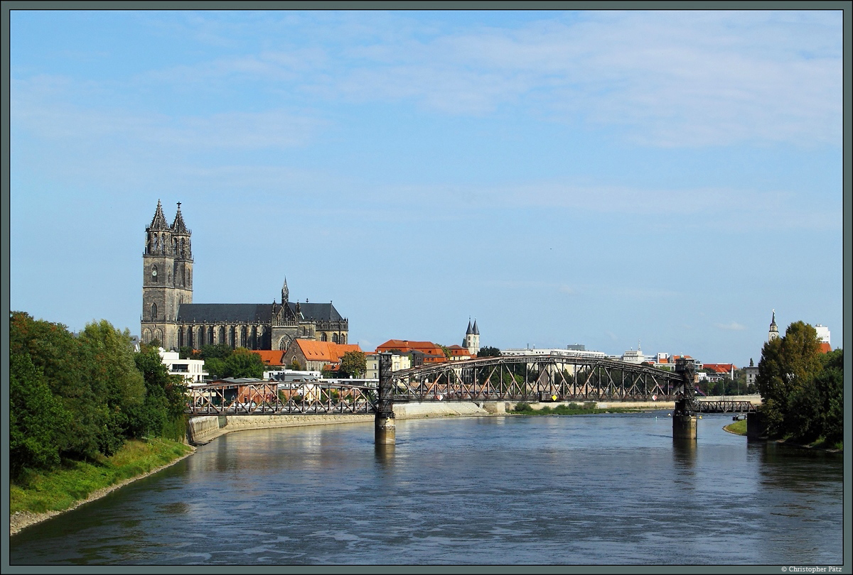 Blick von der Sternbrcke auf die Hubbrcke und den Magdeburger Dom: ber die Hubbrcke fhrte einst die Bahnstrecke nach Biederitz, am Elbufer befand sich der erste Bahnhof von Magdeburg. Heute ist das Gebiet mit Neubauten berbaut, die Hubbrcke kann nur noch von Fugngern genutzt werden. Rechts des Domes ist das Kloster Unser Lieben Frauen erkennbar. (Magdeburg, 03.09.2014)