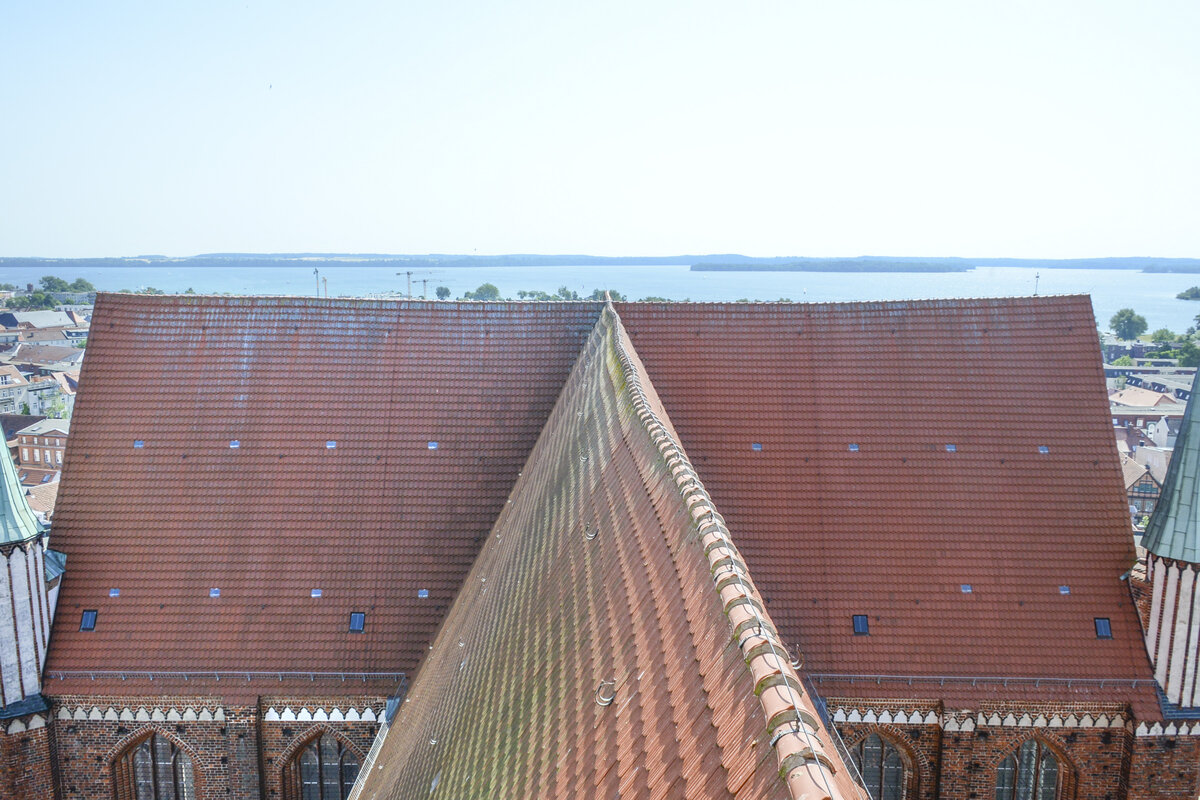 Blick vom Turm auf den Dachstuhl des Schweriner Doms. Im Hintergrund ist die Schweriner See zu sehen. Aufnahme: 18. Juni 2022.
