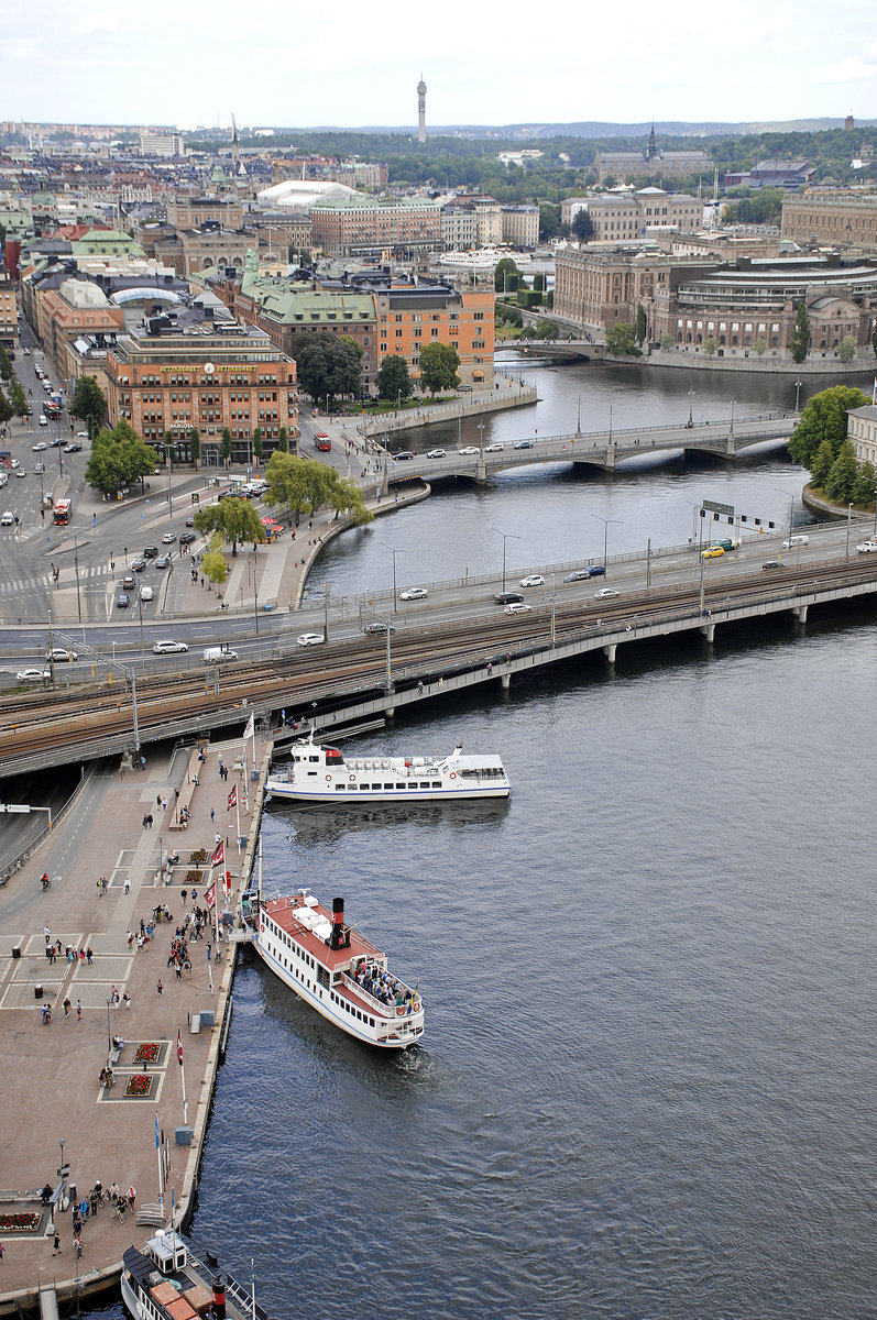 Blick vom Turm des Stadshuset in Stockholm. Im Vordergrund sind die Eisenbahnbrcke Centralbron bzw. die Brcke Vasabron zu sehen. Oben rechts im Bild ist der schwedische Reichstag (Riksdagen) zu sehen. Aufnahme: 25. Juli 2017.